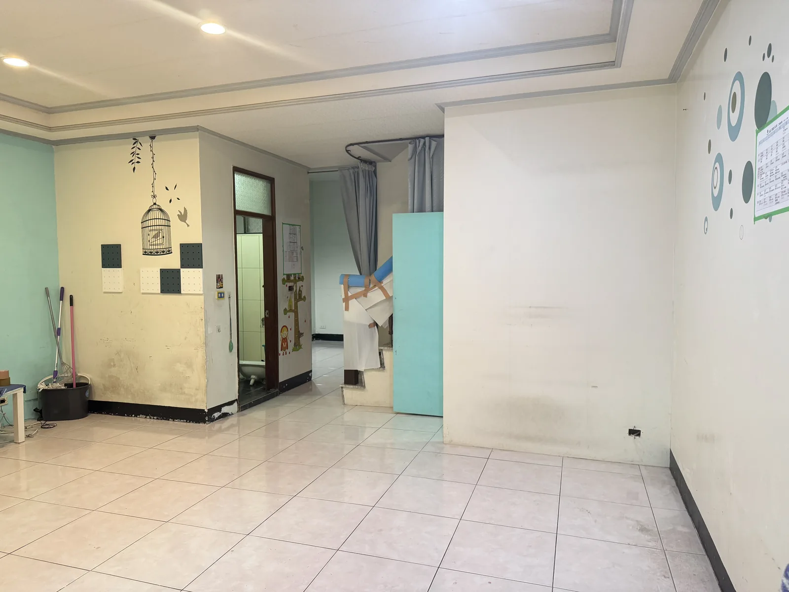 施工前：客廳空曠，左側是客廁，樓梯下儲藏室的門直接開在客廳
